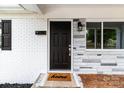Close-up of the front door with stone accents, a modern light fixture, and a welcoming 'home' doormat at 1306 Klondale Ave, Kannapolis, NC 28081