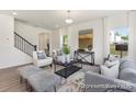 Stylish living room features a staircase, large windows, and comfortable seating arrangements at 2307 Bulwarks Ct # 5P, Albemarle, NC 28001