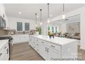 Open-concept kitchen boasts white cabinetry, stainless appliances, and an island with bar seating at 2309 Bulwarks Ct # 4P, Albemarle, NC 28001