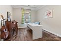 Bright home office with hardwood floors, a large white desk, and a peaceful view from the window at 2322 Morrison Rd, York, SC 29745