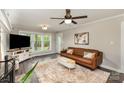 Comfortable living room featuring a leather sofa, decorative rug, and bright windows at 2514 King Arthur Dr, Monroe, NC 28110