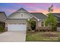 Charming brick home with a two-car garage, beautiful landscaping and a welcoming front entry at sunset at 3618 Marchers Trace Dr, Mint Hill, NC 28227
