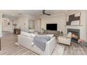 Bright living room featuring neutral decor, fireplace, ceiling fan, and comfortable seating arrangement at 3618 Marchers Trace Dr, Mint Hill, NC 28227