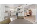 Open concept kitchen featuring white cabinetry, stainless steel appliances, and hardwood floors at 3619 Bankston Pl, Charlotte, NC 28215
