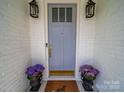 Close-up of an elegant front door with stylish sconces and charming floral accents at 3700 Carolina Cherry Ct, Gastonia, NC 28056