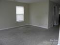 Cozy living room with neutral walls, plush carpeting, and a bright window at 391 Morning Dew Dr, Concord, NC 28025