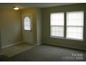 Bright living room featuring neutral walls, plush carpeting, and large windows with natural light at 391 Morning Dew Dr, Concord, NC 28025