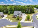 Aerial view of two-story home with brick and stone, three-car garage, detached garage, and manicured lawns at 4008 Pinot Way, Fort Mill, SC 29707