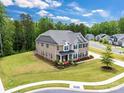 Two-story home with brick and stone exterior, a three-car garage, detached garage, and tree-lined street at 4008 Pinot Way, Fort Mill, SC 29707