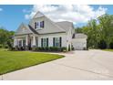 Attractive home featuring a well-maintained lawn, long driveway, black shutters, an American flag, and attached garage at 500 Chicory Cir, Matthews, NC 28104