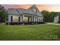 Charming home with a manicured lawn, covered porch with rocking chairs, and classic white columns exudes curb appeal at 500 Chicory Cir, Matthews, NC 28104