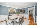 Dining room showcasing modern art, a gray wash table, hardwood floors, and contemporary chairs at 5206 Morrowick Rd, Charlotte, NC 28226