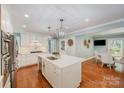 Eat-in kitchen features an island, pendant lighting, a stainless refrigerator, and hardwood floors at 5206 Morrowick Rd, Charlotte, NC 28226