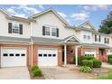Inviting townhome with brick accents, white siding, manicured landscaping, and attached garages at 5310 Waverly Lynn Ln, Charlotte, NC 28269