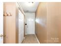 Hallway featuring neutral walls, coat hooks, storage closet and a white front door at 5310 Waverly Lynn Ln, Charlotte, NC 28269