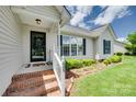 Inviting front porch with brick steps, decorative railing, and manicured greenery enhancing curb appeal at 605 Summey Farm Dr, Dallas, NC 28034