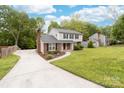 Spacious two-story home with a long driveway, lush green lawn, and mature trees providing ample shade at 616 Silversmith Ln, Charlotte, NC 28270