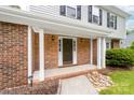 Inviting front porch with brick columns, a stylish front door, and manicured landscaping around the entrance at 616 Silversmith Ln, Charlotte, NC 28270