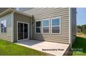 A concrete back patio area with sliding glass door and picture windows, perfect for relaxing and entertaining at 906 Two Brothers Ln, York, SC 29745