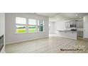 Open-concept living room and kitchen area filled with natural light from the large picture windows at 906 Two Brothers Ln, York, SC 29745
