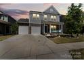 Charming two-story home with stone accents, a well-manicured lawn, and a spacious two-car driveway at dusk at 980 Bunker Trce, Rock Hill, SC 29730