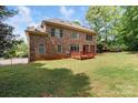 Large backyard featuring a deck, mature trees and partial fence at 10836 Fox Hedge Rd, Matthews, NC 28105