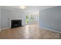 Open-concept living room featuring a fireplace, tile floors, and a seamless transition to the dining area at 10943 Winterbourne Ct, Charlotte, NC 28277