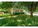 Beautiful home with a welcoming front porch, lush green lawn, and mature trees, perfect for families at 12016 Gemstone Ct, Charlotte, NC 28269