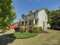 Two-story home showcasing manicured landscaping, a covered porch, and light-green exterior siding at 1222 Kings Bottom Dr, Fort Mill, SC 29715