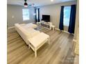 Bright living room with stylish wood-look floors, ceiling fan, and comfortable seating area at 126 Pleasant Hill St, Lancaster, SC 29720
