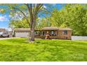 Charming brick home featuring a well-maintained lawn, attached two-car garage, and mature tree in a quiet neighborhood at 1279 Rocky Creek Rd, Shelby, NC 28152