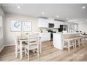 Bright kitchen with a dining nook and white cabinets, stainless steel appliances, and a spacious island with seating at 129 Millstream Dr, China Grove, NC 28023