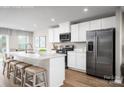 Modern kitchen featuring white cabinets, stainless steel appliances, and a spacious island with seating at 129 Millstream Dr, China Grove, NC 28023