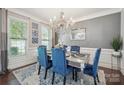 Elegant dining room with a crystal chandelier, large windows, and stylish decor at 13402 David Jennings Ave, Charlotte, NC 28213