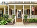Inviting front porch with brick steps, white railings, and well-maintained landscaping at 172 Harper Lee St, Davidson, NC 28036