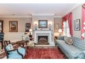 Elegant living room with fireplace, patterned furniture, decorative art, and refined accents at 172 Harper Lee St, Davidson, NC 28036