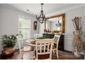 Elegant dining room with hardwood floors, chandelier, and a decorative mirror above a stylish buffet at 21136 Cold Spring Ln, Cornelius, NC 28031