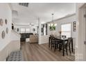 Open-concept dining room with modern chandelier, wood floors, and a seamless transition to the living area at 246 Mallard Head Dr, Rock Hill, SC 29732