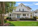 Charming two-story home with a welcoming front porch, swing, and beautifully manicured lawn at 309 Catawba Ave, Davidson, NC 28036