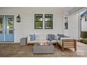 Relaxing covered outdoor patio with a cozy fire pit and comfortable seating area at 309 Catawba Ave, Davidson, NC 28036