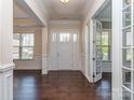 Elegant foyer with hardwood floors, crown molding, and a white front door with glass inserts at 323 Cheshire Ln, Fort Mill, SC 29707