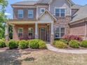 Charming front entrance featuring a brick porch, stone columns and carefully manicured landscaping at 323 Cheshire Ln, Fort Mill, SC 29707