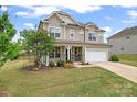 Beautiful two-story home with manicured lawn, stone accents, covered porch, and an attached garage at 341 Pleasant Hill Se Dr, Concord, NC 28025