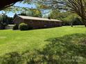A well-maintained brick home with a metal roof and spacious yard, framed by lush trees at 370 Sherrill Farm Rd, Lincolnton, NC 28092