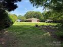 A single-story brick home with an attached garage and carport sits on a large, grassy lot with mature trees at 370 Sherrill Farm Rd, Lincolnton, NC 28092