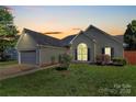 Charming home with a well-maintained lawn, tidy landscaping, and an inviting curb appeal at dusk at 4606 Falcon Chase Sw Dr, Concord, NC 28027