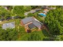 Aerial view of a house showcasing the backyard with swimming pool, landscaping, and screened in porch at 4611 Cringle Ct, Charlotte, NC 28226