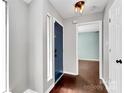 Home entryway with a blue front door, hardwood floors, and modern lighting fixtures at 6712 Santa Maria Ln, Charlotte, NC 28227