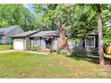 Inviting single-story home featuring well-kept landscaping, a brick chimney, and an American flag at 6712 Santa Maria Ln, Charlotte, NC 28227