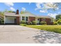 Well-maintained red brick home with a carport, manicured lawn, and inviting front entrance at 7209 Marley Cir, Charlotte, NC 28214